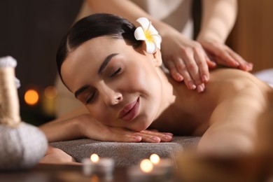 Photo of Spa therapy. Beautiful young woman lying on table during massage in salon