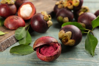 Purple mangosteen powder and fruits on light blue wooden table