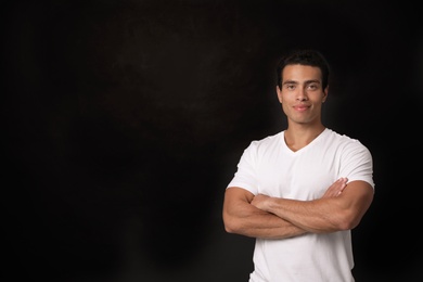 Handsome young African-American man on black background. Space for text