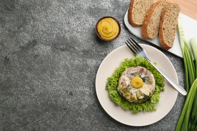 Delicious aspic with meat and vegetables served on grey table, flat lay. Space for text