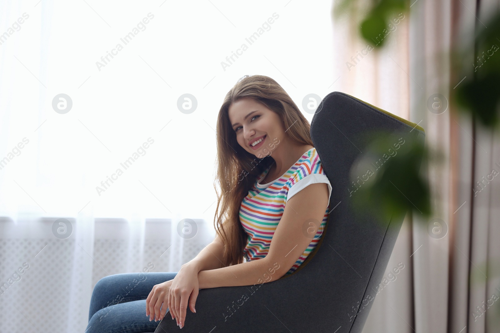 Photo of Young woman resting in armchair at home