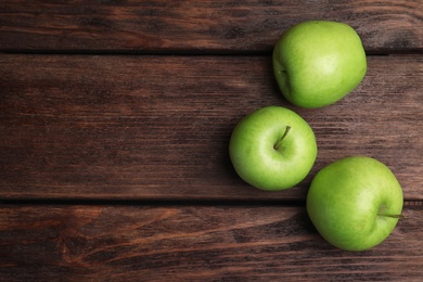 Photo of Fresh ripe green apples on wooden table, flat lay. Space for text