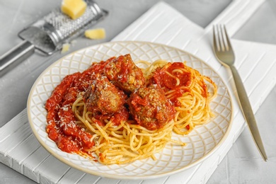 Photo of Delicious pasta with meatballs and tomato sauce on table