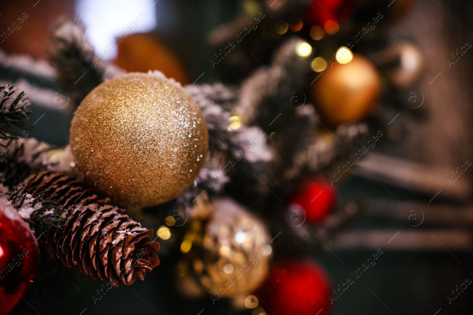 Photo of Beautiful Christmas ball and fir cone on blurred background, closeup