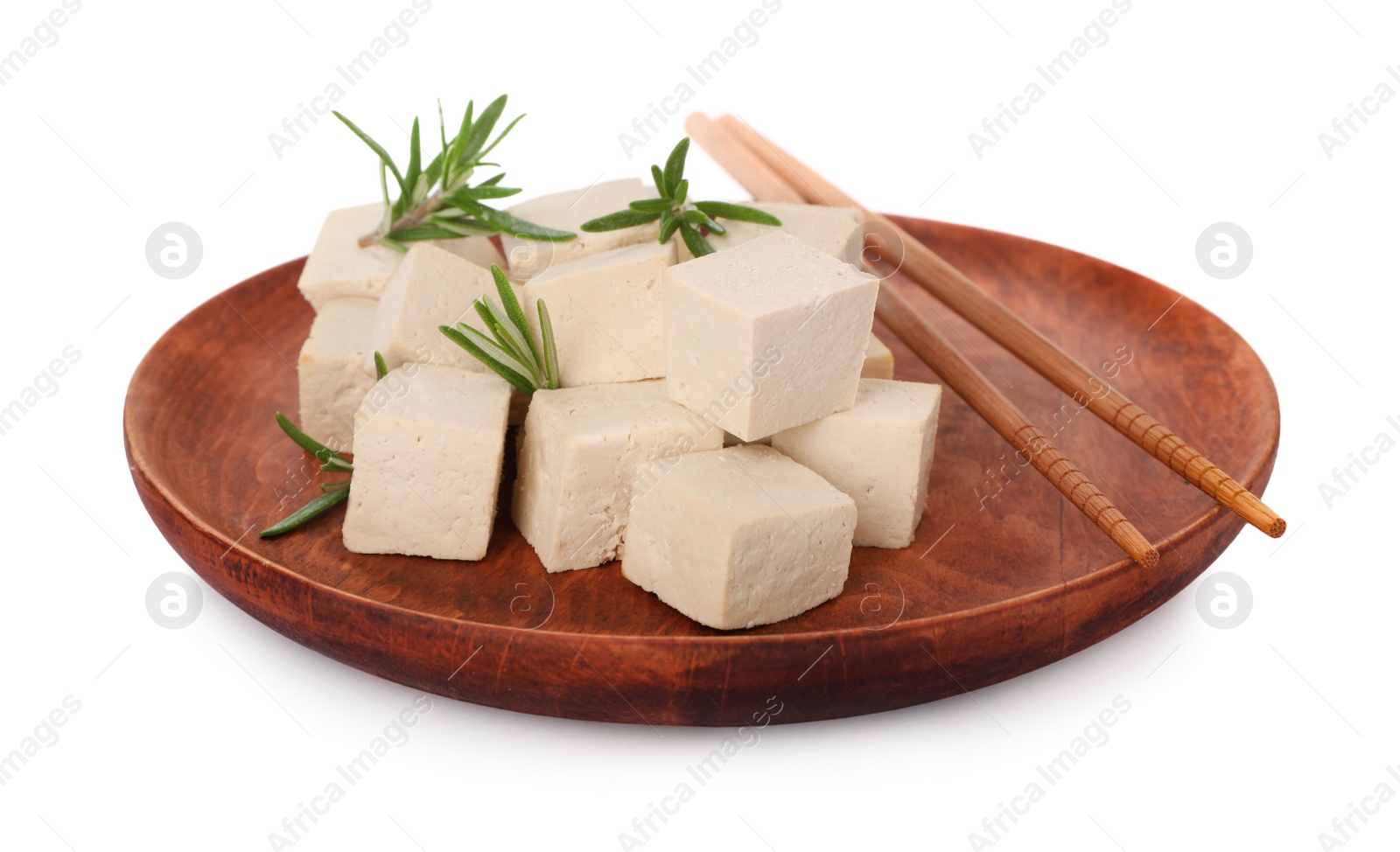 Photo of Wooden plate with delicious tofu, rosemary and chopsticks isolated on white