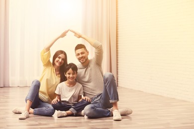 Image of Happy family forming house roof with their hands at home. Insurance concept