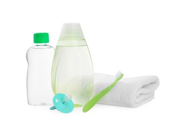 Different skin care products for baby in bottles, pacifier, toothbrush and towel isolated on white