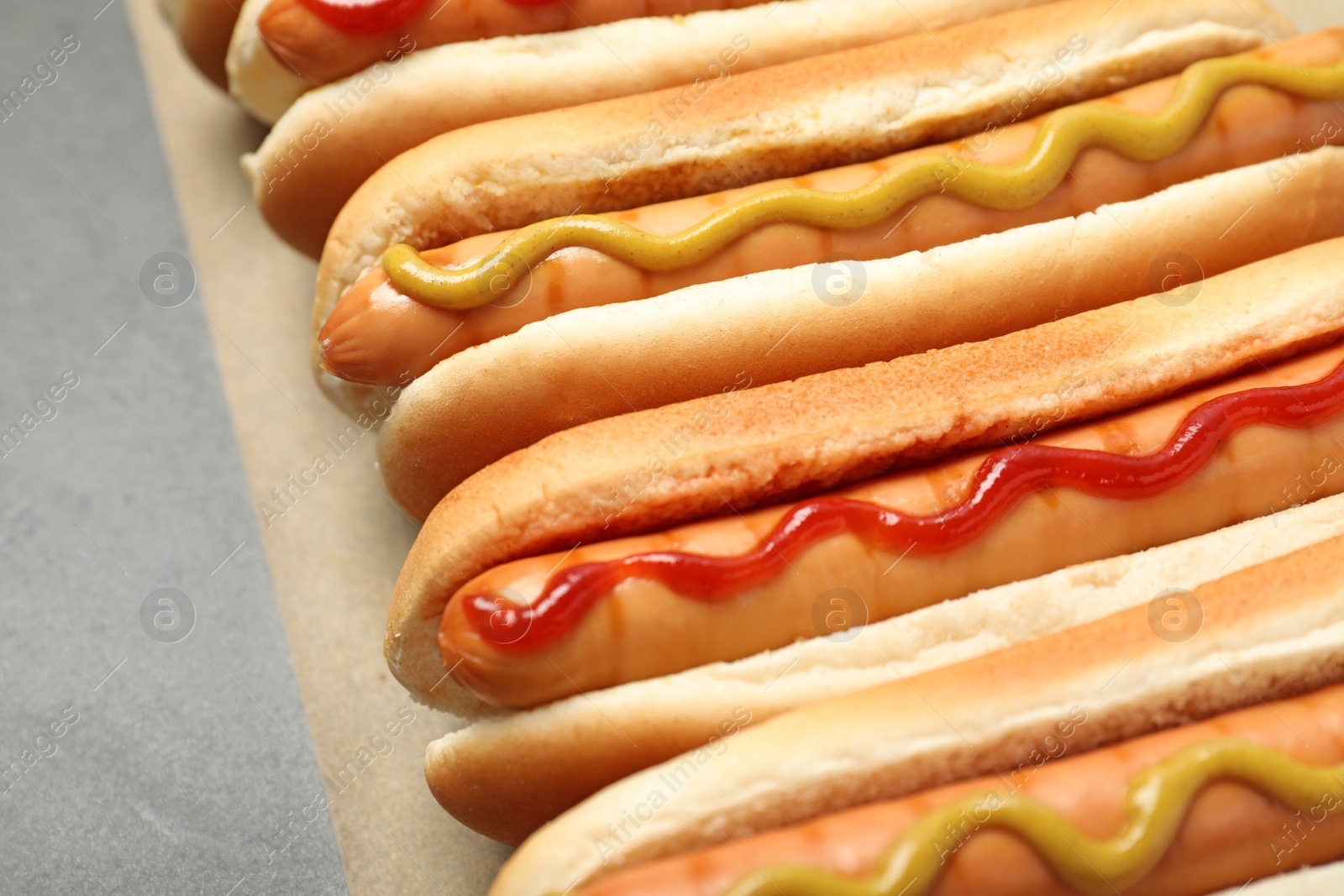 Photo of Tasty fresh hot dogs on grey table, closeup