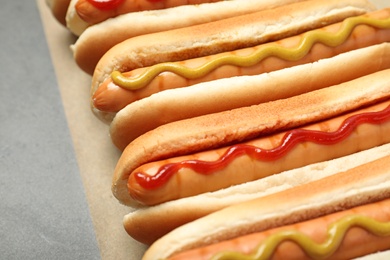 Tasty fresh hot dogs on grey table, closeup