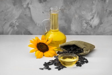 Sunflower, oil and seeds on white table