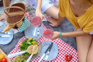 Photo of Young women having picnic outdoors on summer day, closeup