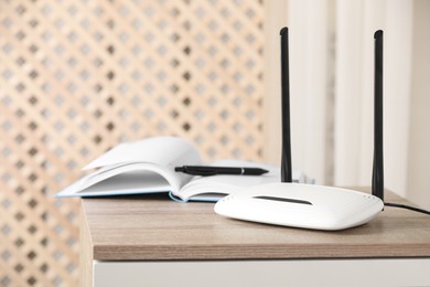 Photo of Modern Wi-Fi router indoors. Space for text