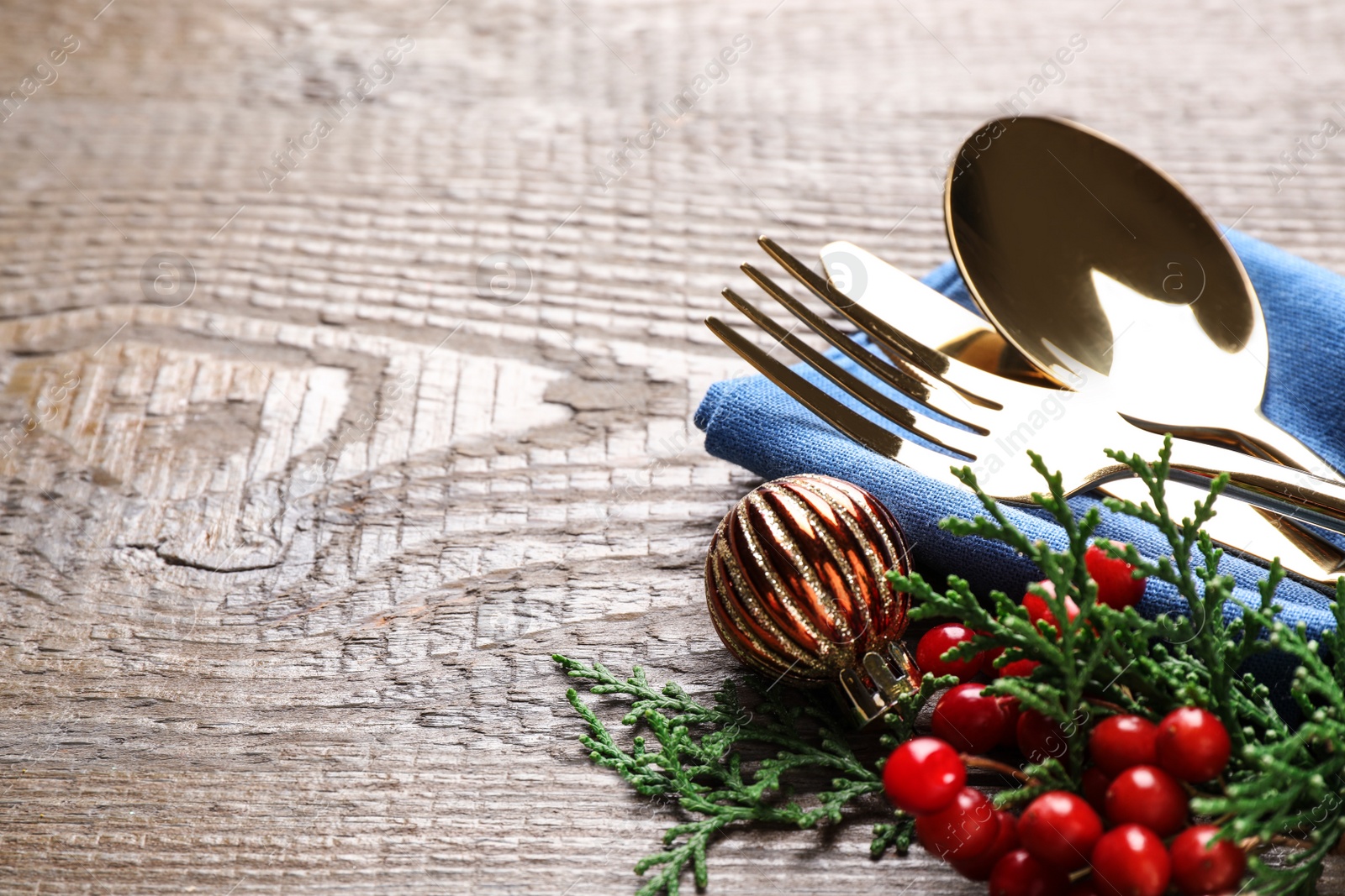 Photo of Cutlery set on wooden table, closeup view with space for text. Christmas celebration