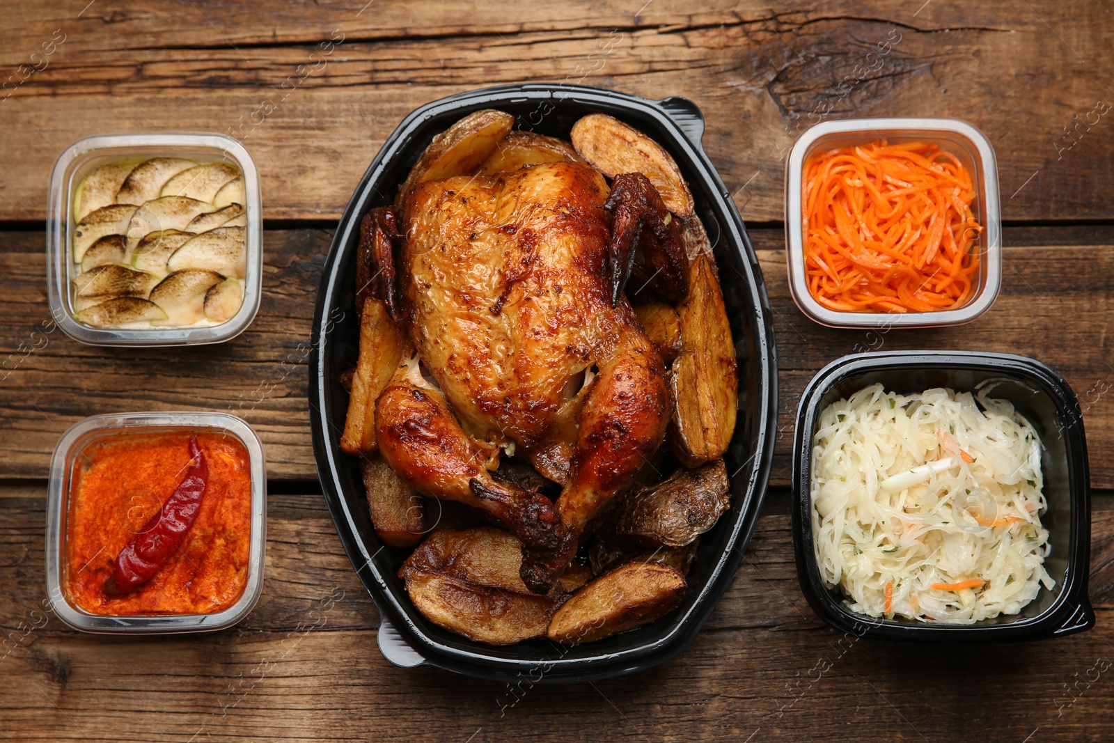 Photo of Plastic containers with different dishes on wooden table, flat lay. Food delivery service