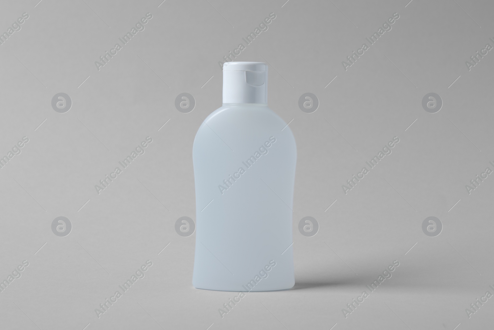 Photo of Bottle of cosmetic product on light grey background