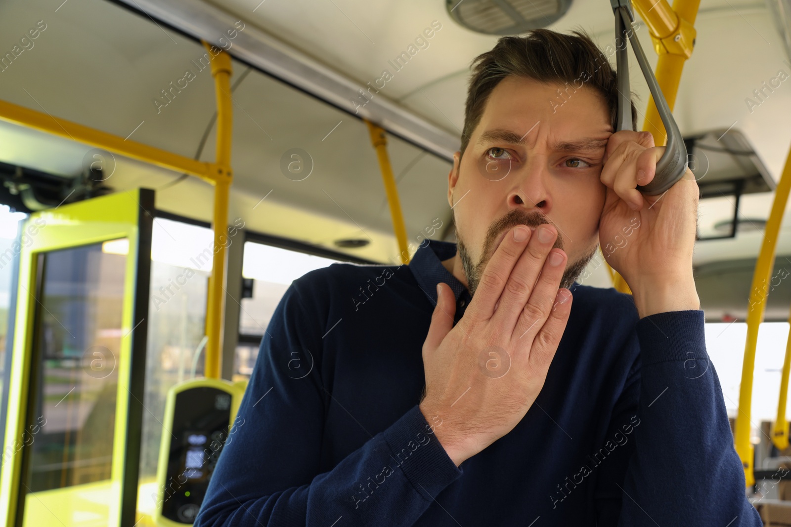 Photo of Sleepy tired man yawning in public transport