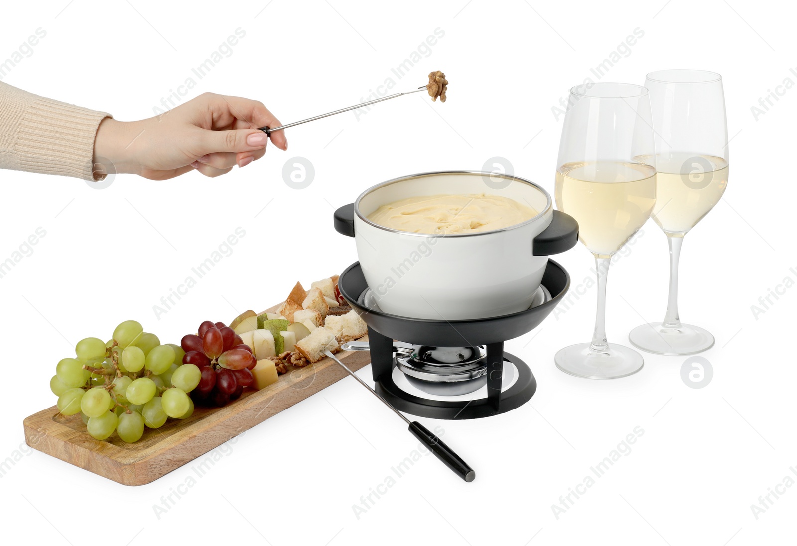 Photo of Woman holding fork with walnut above fondue pot with melted cheese on white background, closeup