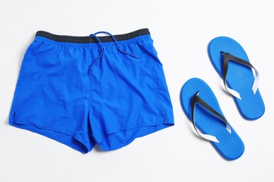 Photo of Flat lay composition with stylish male swim trunks on white background. Beach objects