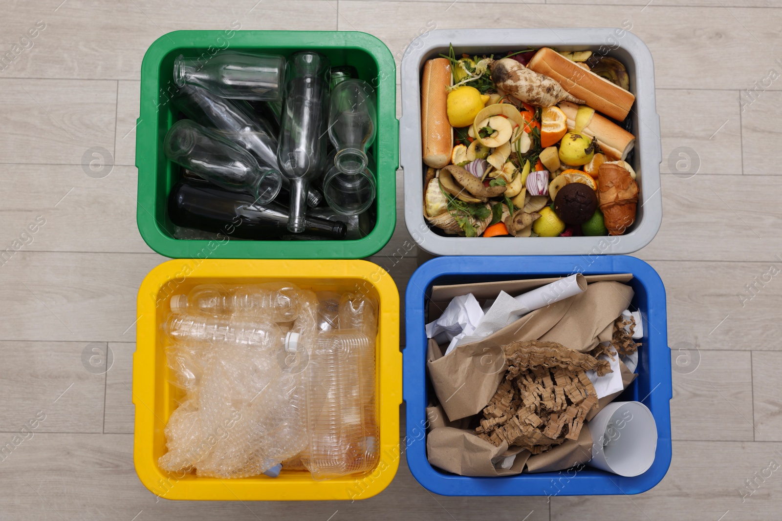 Photo of Garbage sorting. Full trash bins for separate waste collection indoors, top view