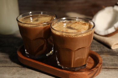 Photo of Glasses of tasty coffee on wooden table, closeup