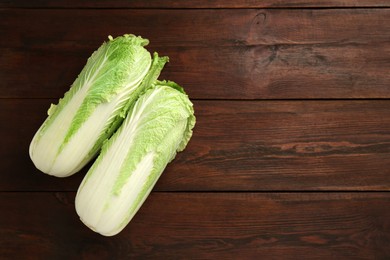 Photo of Fresh ripe Chinese cabbages on wooden table, top view. Space for text