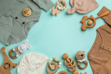 Photo of Frame of baby clothes and accessories on light blue background, flat lay. Space for text