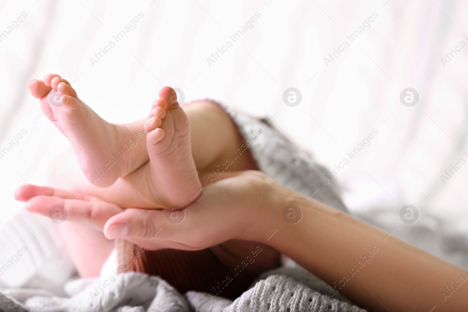 Photo of Mother and her newborn baby on bed, closeup. Space for text