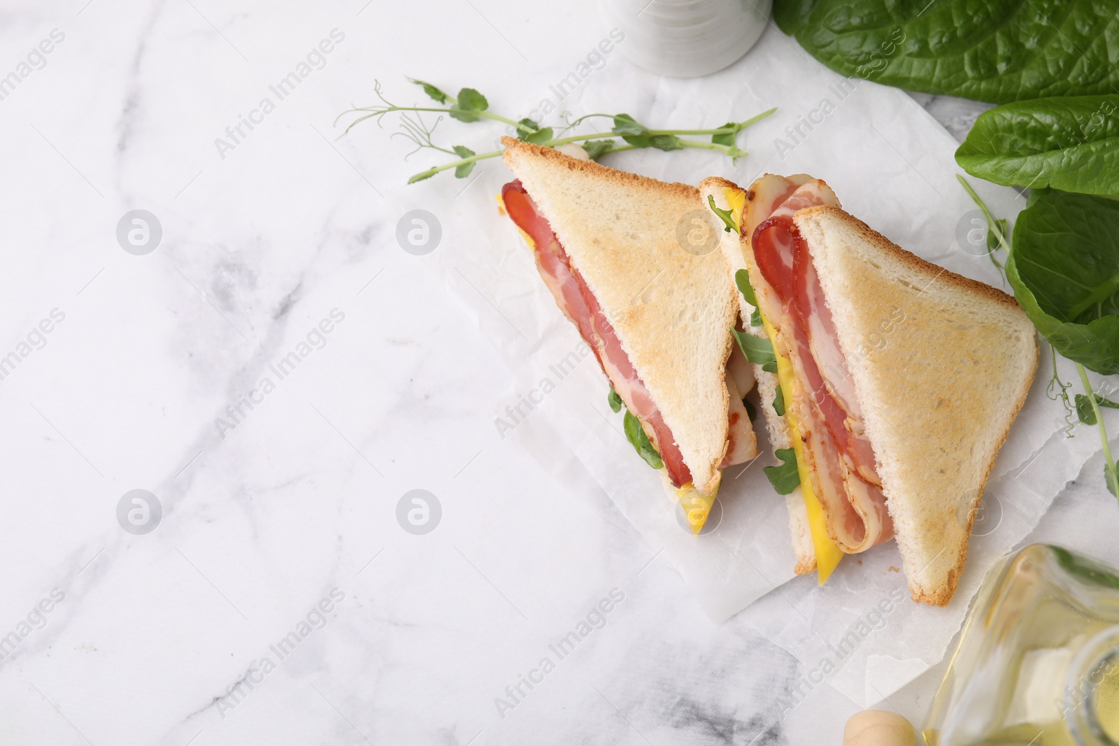 Photo of Delicious sandwiches with bacon on white marble table, flat lay. Space for text