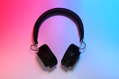 Photo of Stylish headphones on color background, top view