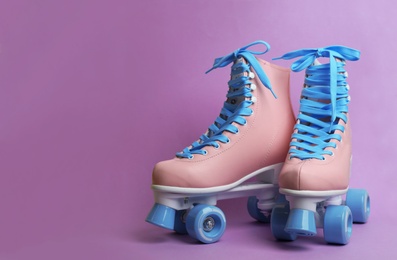 Photo of Pair of stylish quad roller skates on color background. Space for text