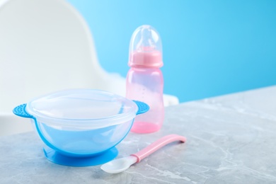 Photo of Set of plastic dishware on grey table. Serving baby food