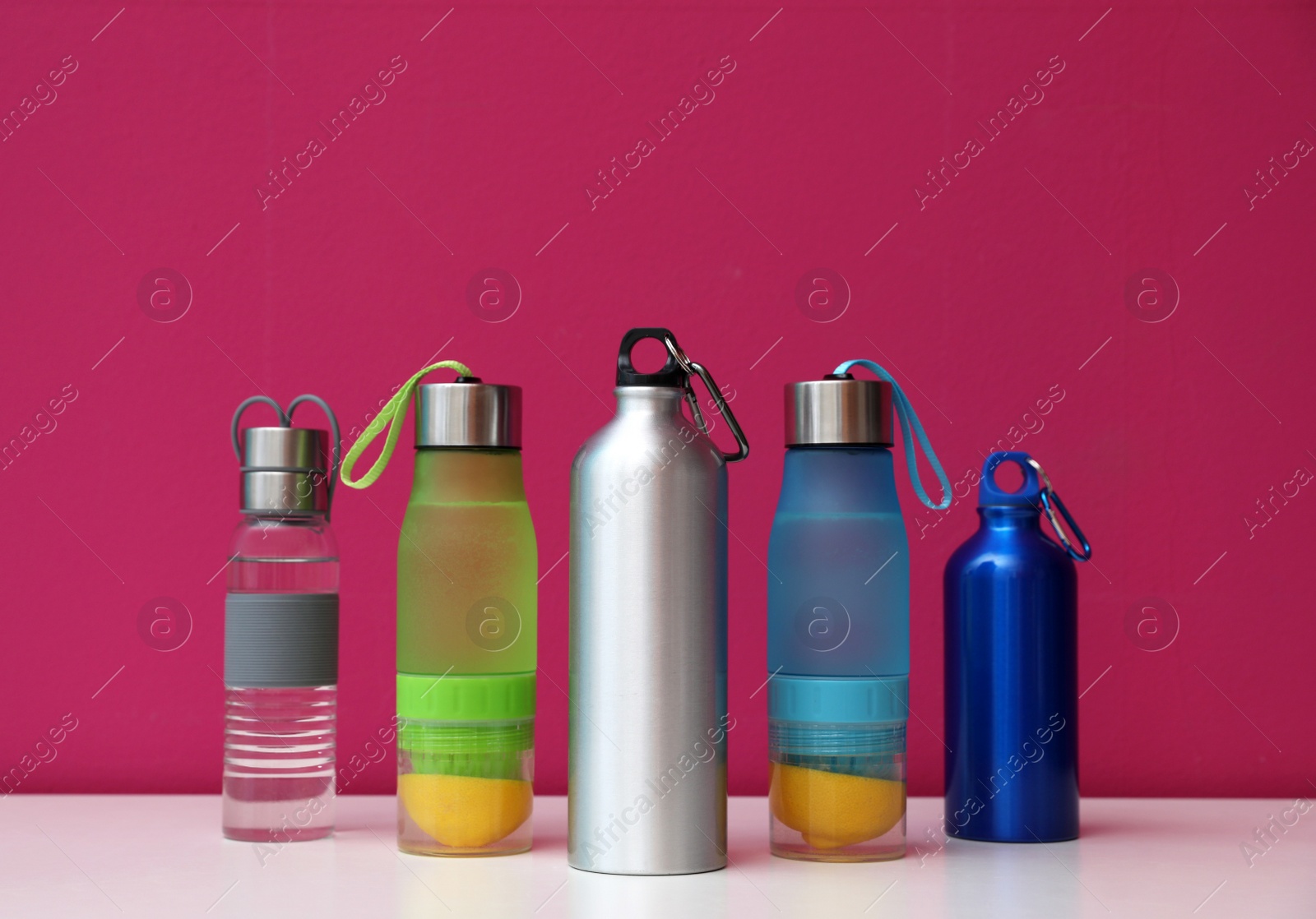 Photo of Different water bottles for sports on color background