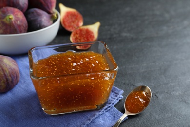 Delicious fig jam in glass bowl on black table, closeup