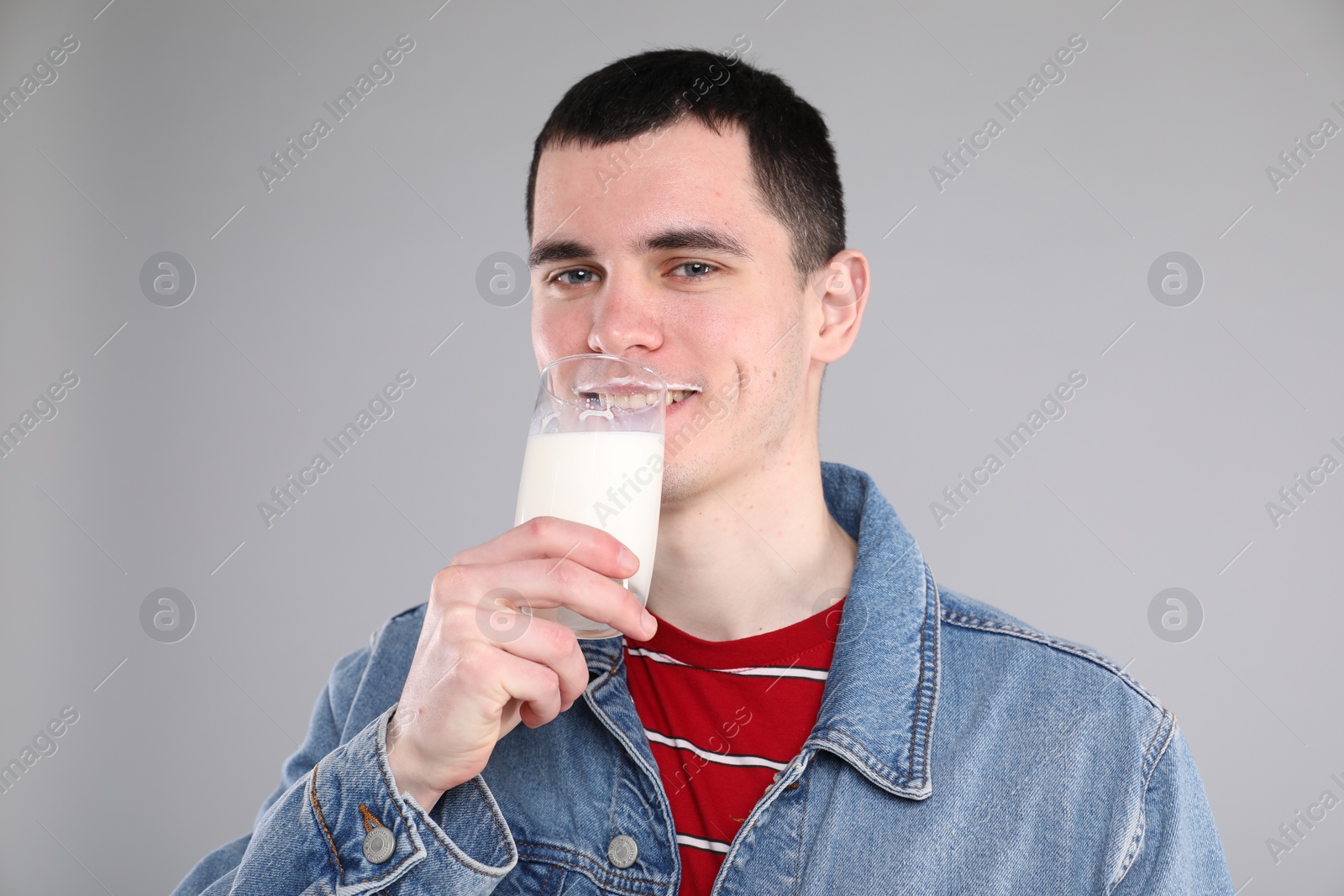 Photo of Milk mustache left after dairy product. Man drinking milk on gray background