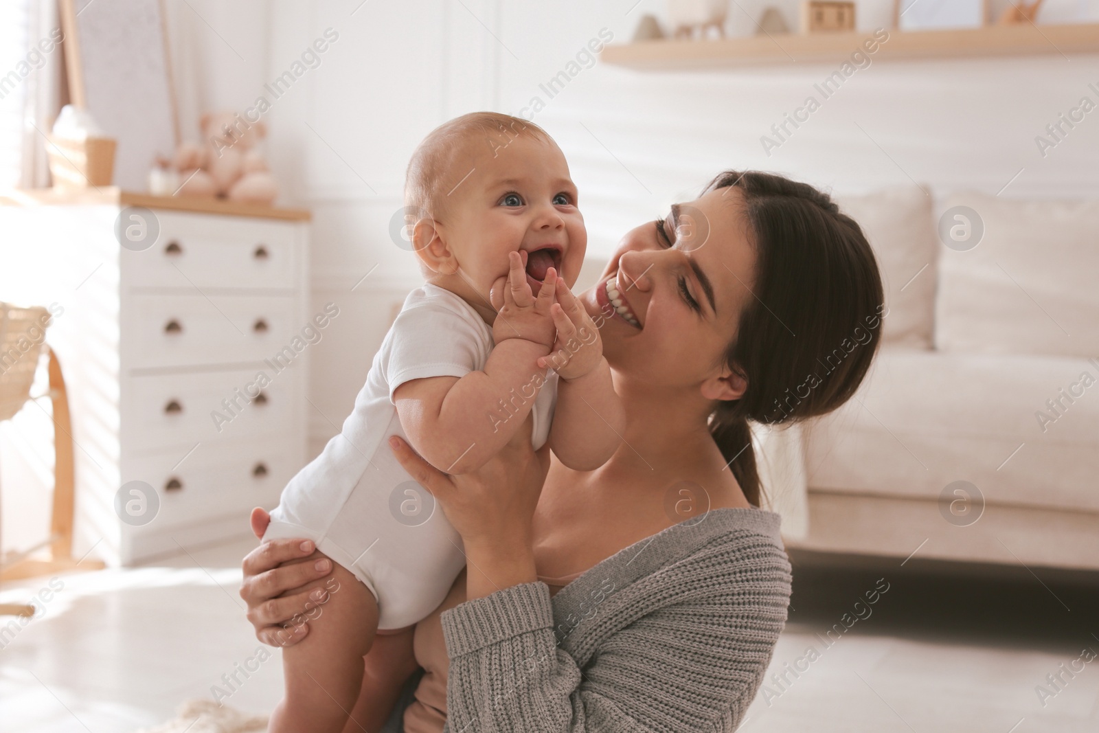 Photo of Happy young mother with her cute baby at home