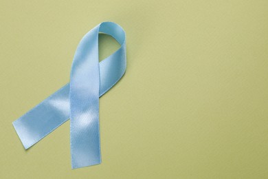 International Psoriasis Day. Ribbon as symbol of support on green background, top view. Space for text