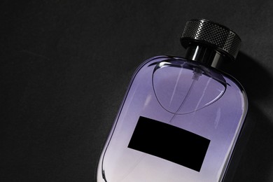 Luxury men`s perfume in bottle on black background, top view. Space for text