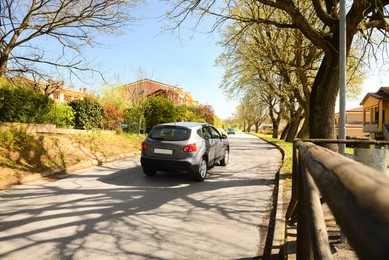 Picturesque view of beautiful suburban street with cars on sunny spring day