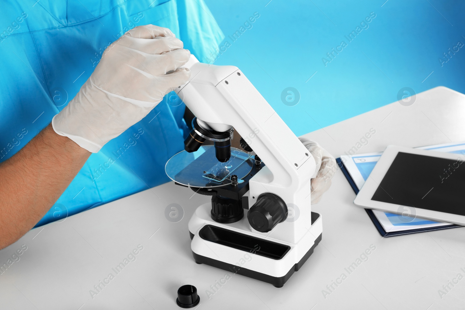 Photo of Male doctor using microscope at table, closeup. Medical object