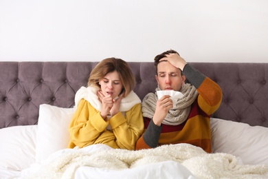 Couple suffering from cold together in bed