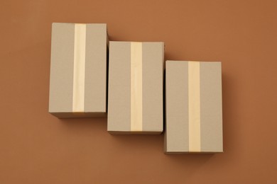 Photo of Cardboard boxes on brown background, flat lay
