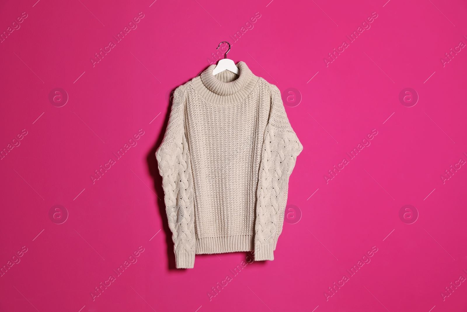 Photo of Hanger with stylish sweater on color background