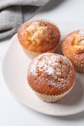 Delicious sweet muffins on white table, closeup