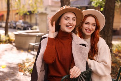 Photo of Happy friends spending time together outdoors on autumn day