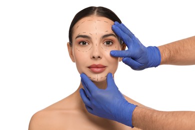 Doctor checking patient's face before cosmetic surgery operation on white background