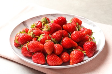 Plate with fresh ripe strawberries on table