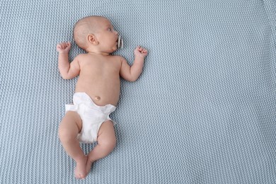 Photo of Little baby in diaper on bed. Space for text