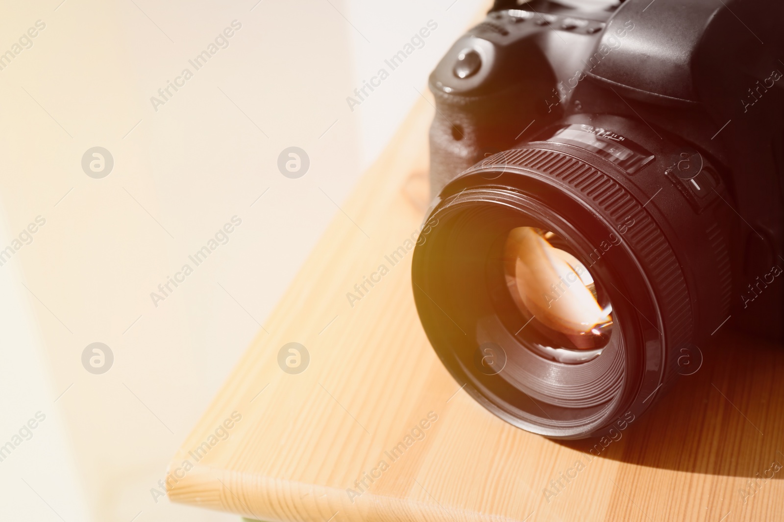 Image of Professional camera on wooden table, space for text. Photographer's equipment