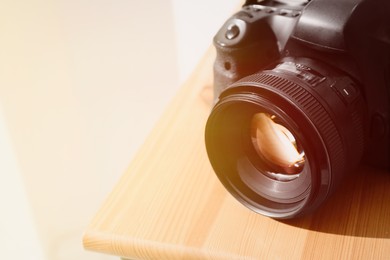 Professional camera on wooden table, space for text. Photographer's equipment