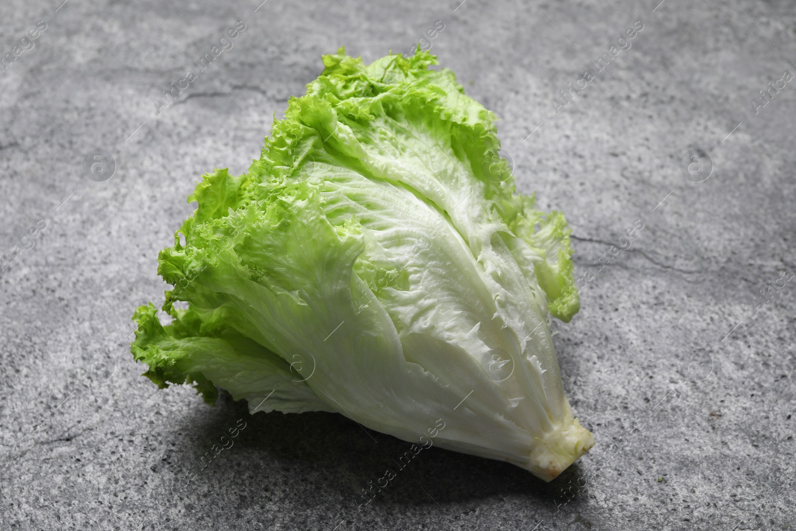 Photo of Fresh lettuce on stone table. Salad greens